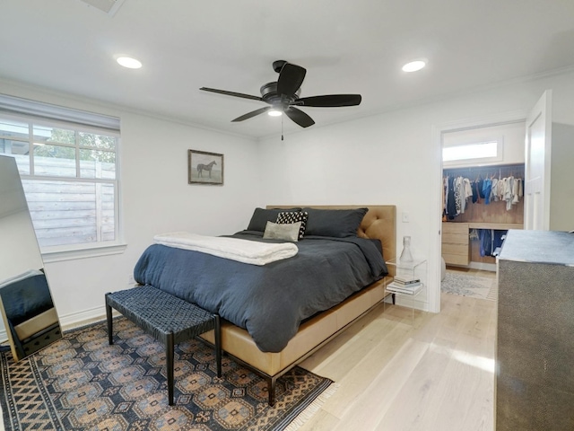 bedroom featuring ornamental molding, light hardwood / wood-style floors, multiple windows, and ceiling fan