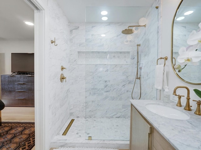 bathroom featuring a tile shower and vanity