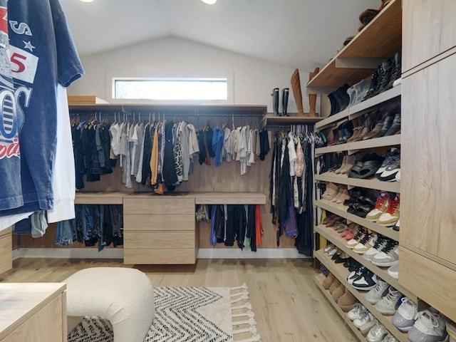 spacious closet featuring light wood-type flooring and vaulted ceiling