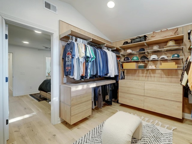 walk in closet with light hardwood / wood-style flooring and vaulted ceiling