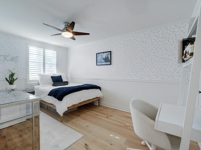 bedroom featuring light hardwood / wood-style flooring, ceiling fan, and crown molding