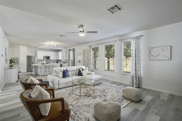 living room featuring light wood-type flooring and ceiling fan