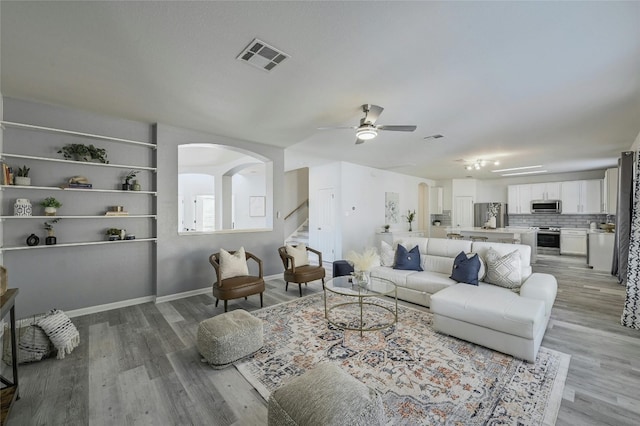 living room with light wood-type flooring and ceiling fan