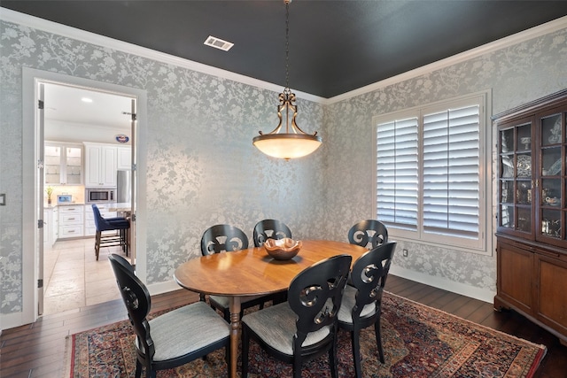 dining area featuring dark hardwood / wood-style floors and ornamental molding