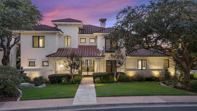 mediterranean / spanish-style house with a lawn