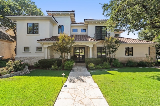 mediterranean / spanish-style house featuring a front yard and french doors