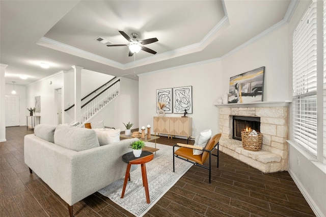 living room with crown molding, a fireplace, and a tray ceiling