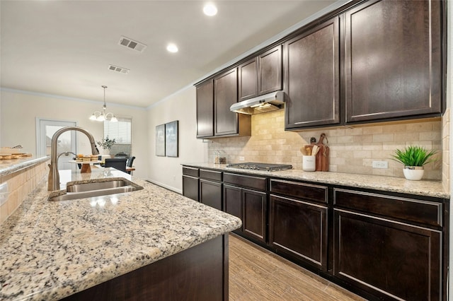 kitchen featuring dark brown cabinets, sink, pendant lighting, and stainless steel gas cooktop