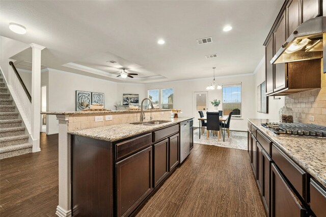 kitchen featuring stainless steel appliances, hanging light fixtures, sink, and dark brown cabinets