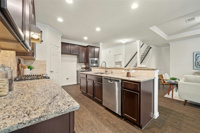 kitchen featuring stainless steel appliances, sink, a kitchen island with sink, and dark hardwood / wood-style floors