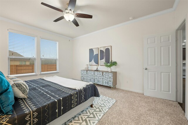 carpeted bedroom with ornamental molding and ceiling fan