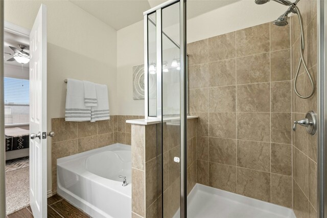 bathroom with ceiling fan and plus walk in shower