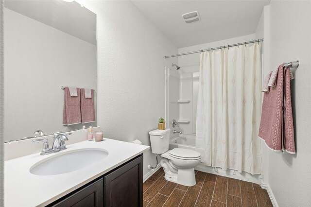 full bathroom featuring shower / tub combo with curtain, vanity, and toilet