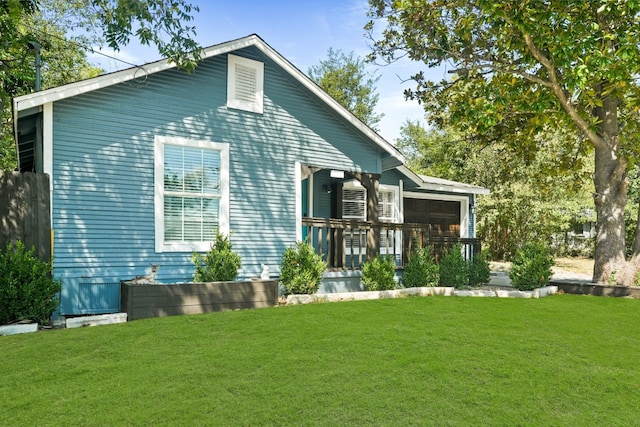 rear view of house featuring a yard and a porch