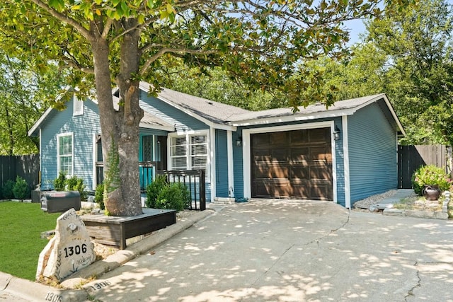 ranch-style home featuring a garage, driveway, and fence