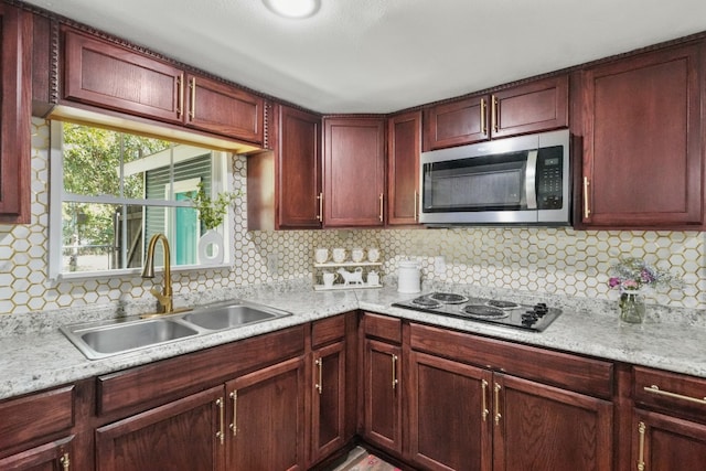 kitchen featuring tasteful backsplash, stovetop, and sink