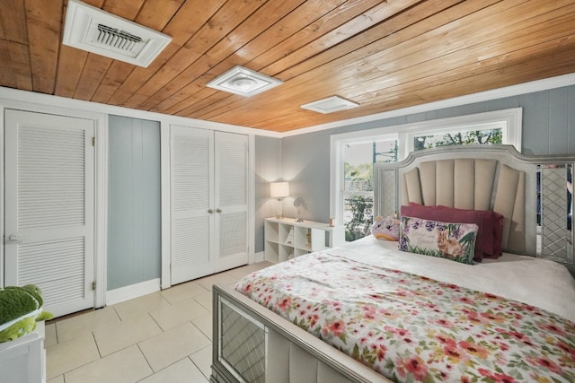 tiled bedroom featuring crown molding, wooden ceiling, and two closets