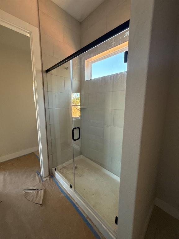 bathroom featuring a shower with door