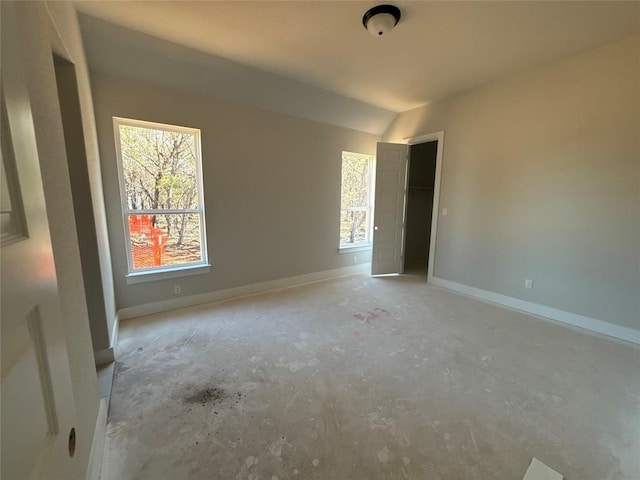 empty room with a wealth of natural light and vaulted ceiling