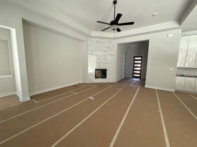 unfurnished living room featuring ceiling fan and a premium fireplace