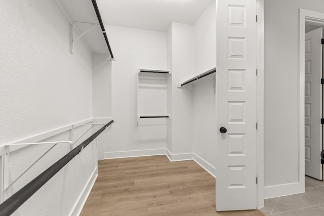 walk in closet with light wood-type flooring