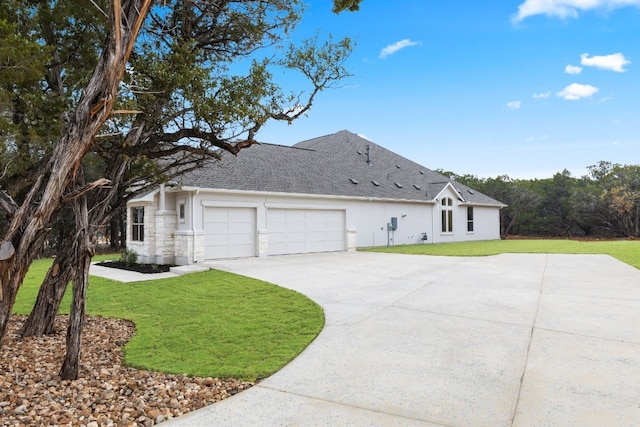 view of home's exterior featuring a lawn, a garage, and driveway