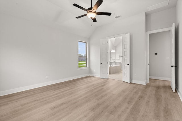 unfurnished bedroom featuring vaulted ceiling, ensuite bathroom, ceiling fan, and light wood-type flooring