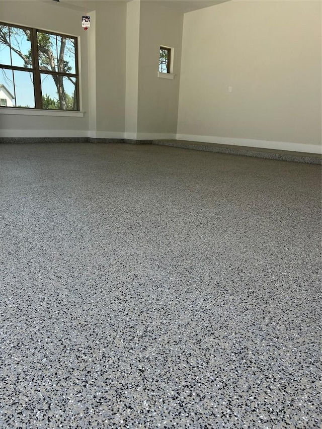 spare room featuring baseboards and speckled floor