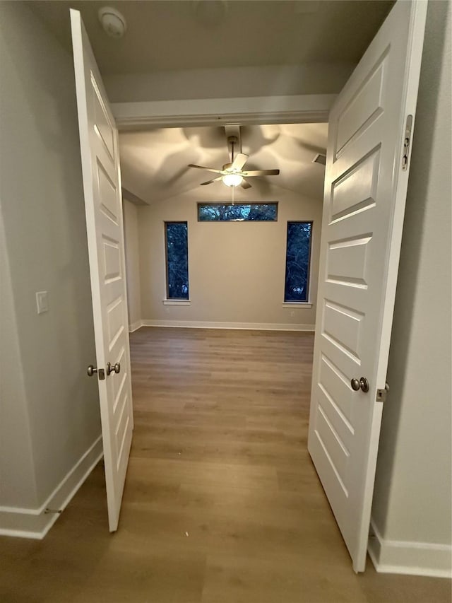 corridor featuring lofted ceiling and hardwood / wood-style floors