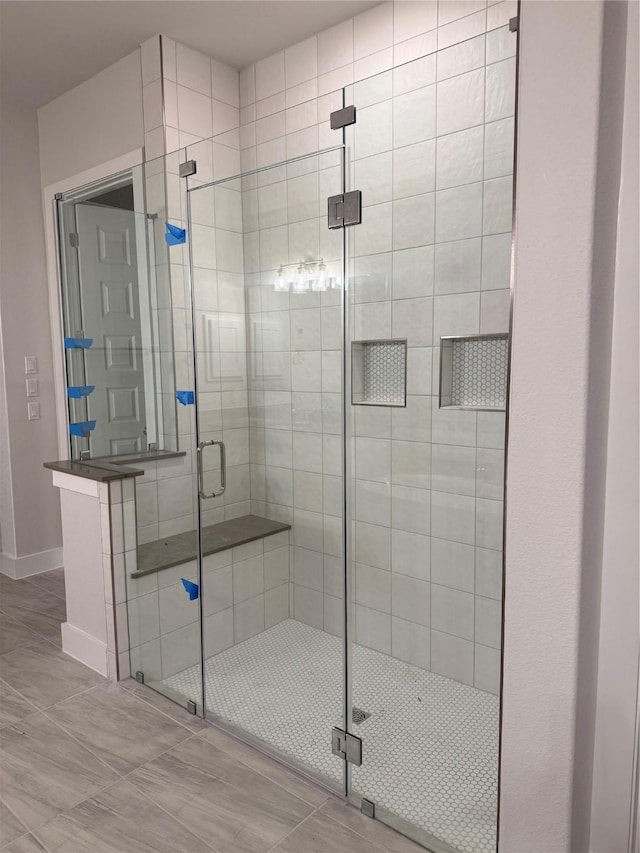 bathroom featuring a shower with door