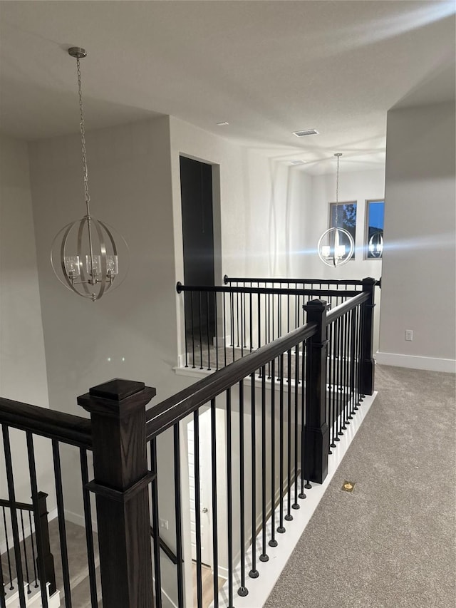 corridor featuring carpet floors and a chandelier