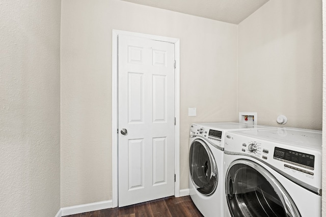 clothes washing area with washing machine and dryer and dark hardwood / wood-style flooring