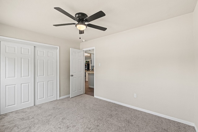 unfurnished bedroom featuring carpet floors, a closet, and ceiling fan