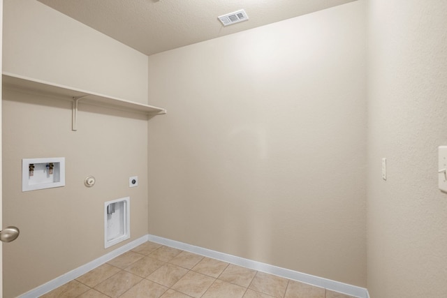 laundry room with light tile patterned flooring, washer hookup, hookup for an electric dryer, a textured ceiling, and gas dryer hookup