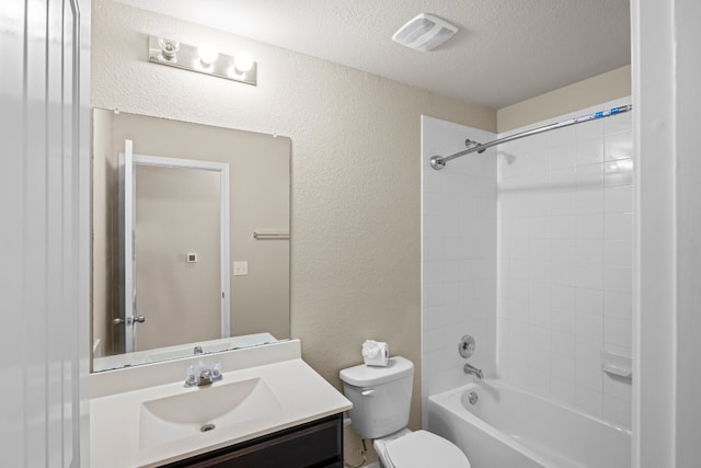 full bathroom with a textured ceiling, tiled shower / bath combo, vanity, and toilet