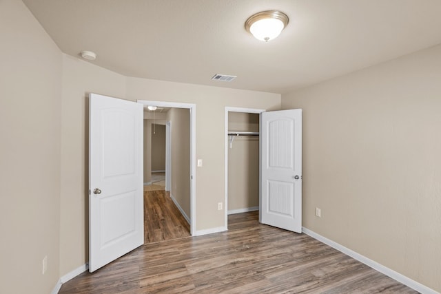 unfurnished bedroom with a closet and hardwood / wood-style floors