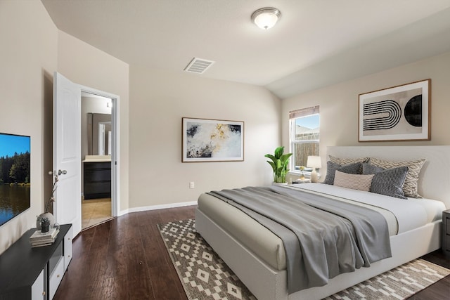 bedroom featuring wood-type flooring, lofted ceiling, and ensuite bathroom