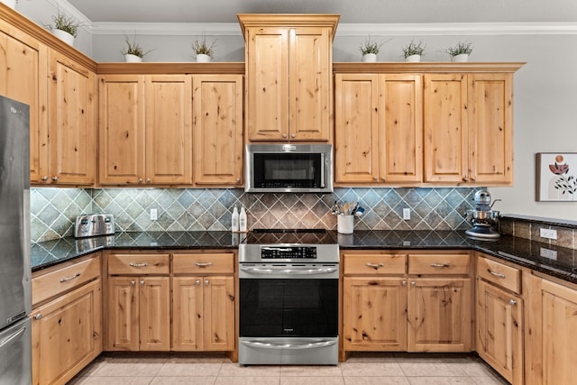 kitchen with light tile patterned floors, ornamental molding, dark stone countertops, backsplash, and stainless steel appliances