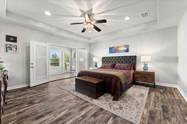 bedroom with a raised ceiling, ceiling fan, access to outside, and dark hardwood / wood-style flooring