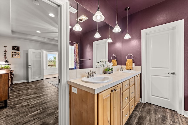 bathroom featuring a raised ceiling, vanity, and hardwood / wood-style flooring