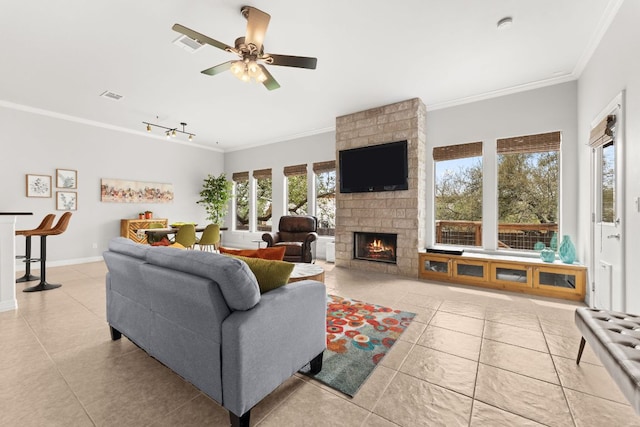 living room with light tile patterned floors, visible vents, a healthy amount of sunlight, and ornamental molding