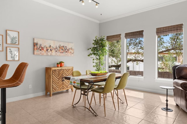 dining room featuring baseboards, light tile patterned flooring, and ornamental molding