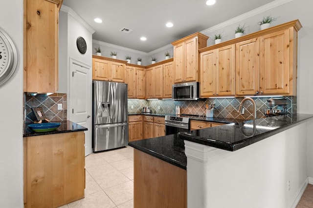 kitchen with a peninsula, stainless steel appliances, tasteful backsplash, and visible vents