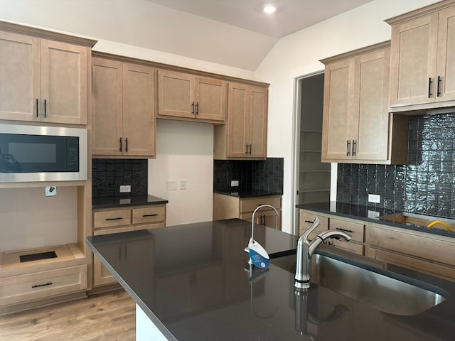 kitchen featuring backsplash, sink, and built in microwave