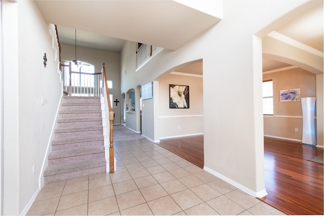 stairs with hardwood / wood-style flooring, crown molding, and a wealth of natural light