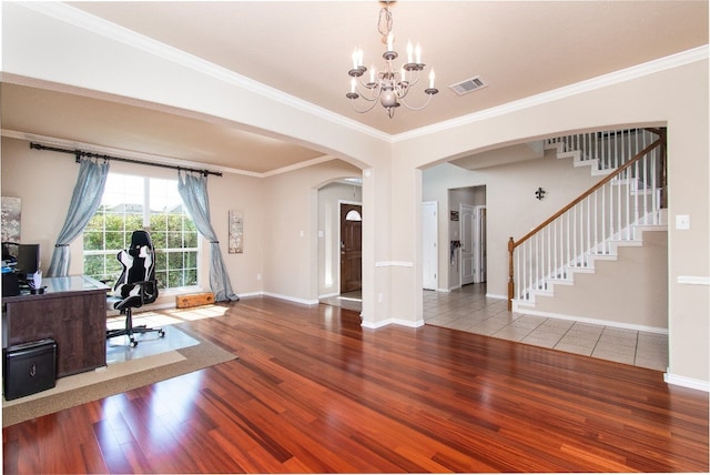 interior space featuring ornamental molding, a notable chandelier, and hardwood / wood-style floors