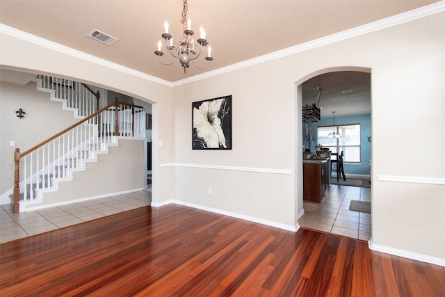 interior space with ornamental molding, hardwood / wood-style flooring, a notable chandelier, and a textured ceiling