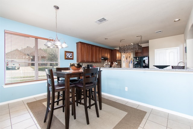 tiled dining room featuring a notable chandelier