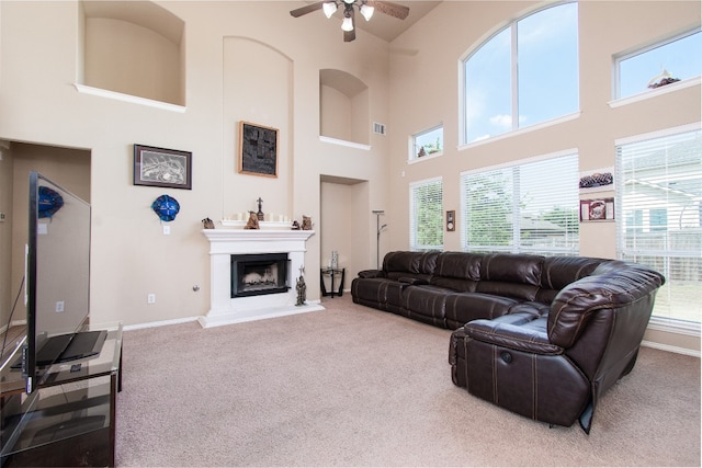 living room featuring carpet, a towering ceiling, and ceiling fan