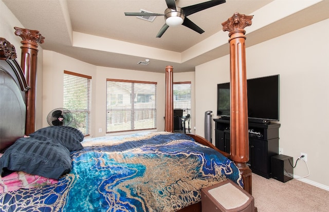 bedroom with ceiling fan, carpet floors, and a tray ceiling